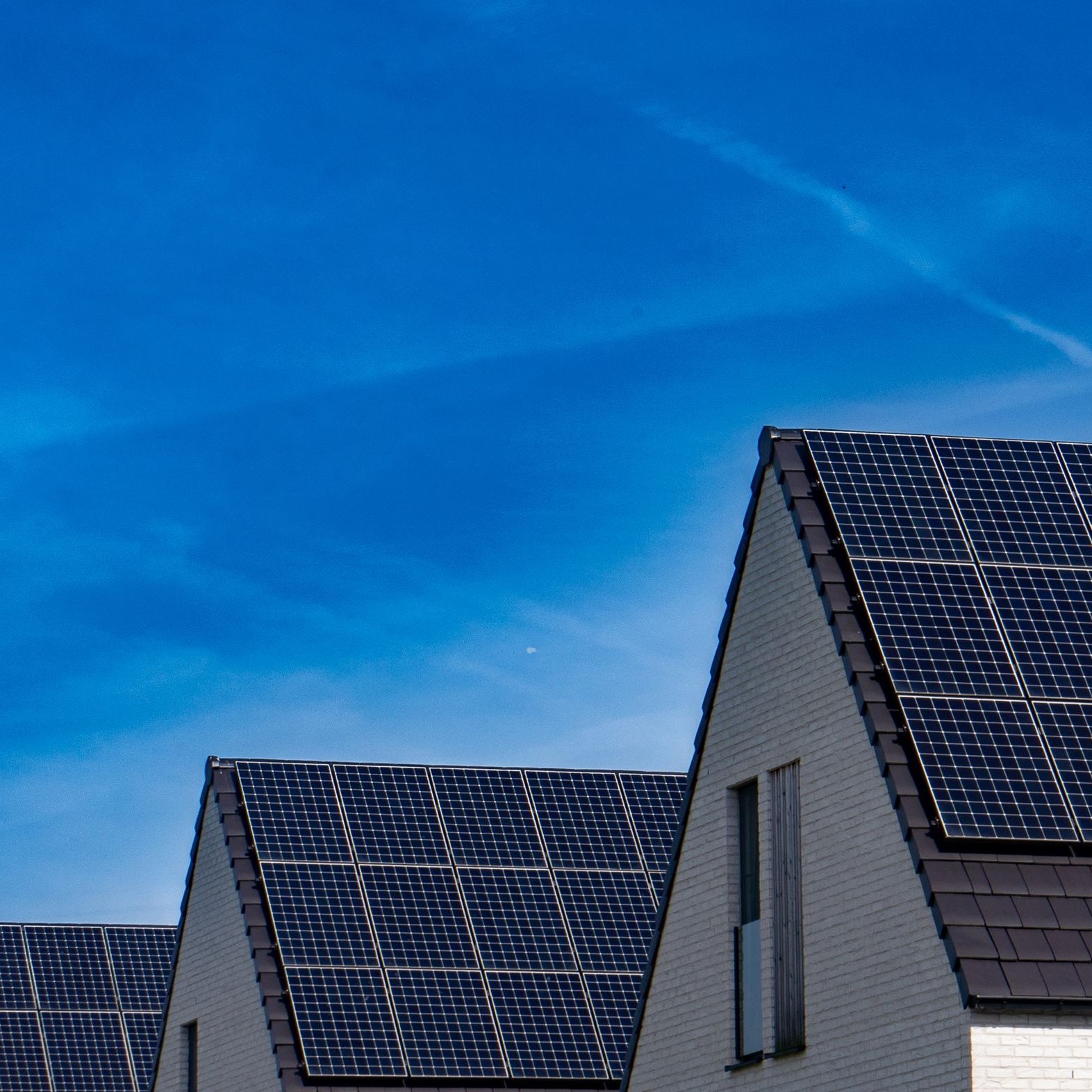 Solaranlage Photovoltaikanlage auf Hausdächern unter blauem Himmel – Solaranlagen von SOS Gebäudetechnik