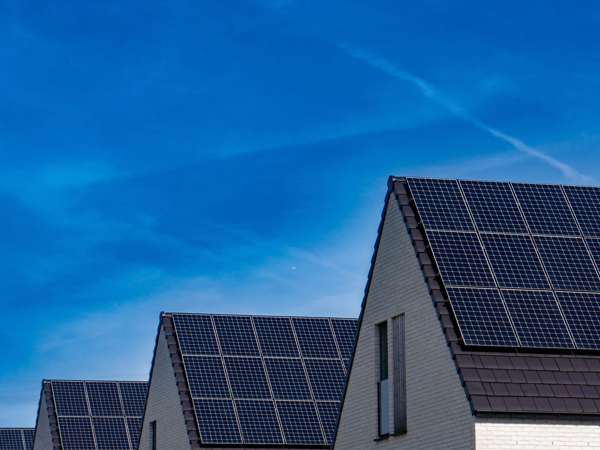 Solaranlage Photovoltaikanlage auf Hausdächern unter blauem Himmel – Solaranlagen von SOS Gebäudetechnik