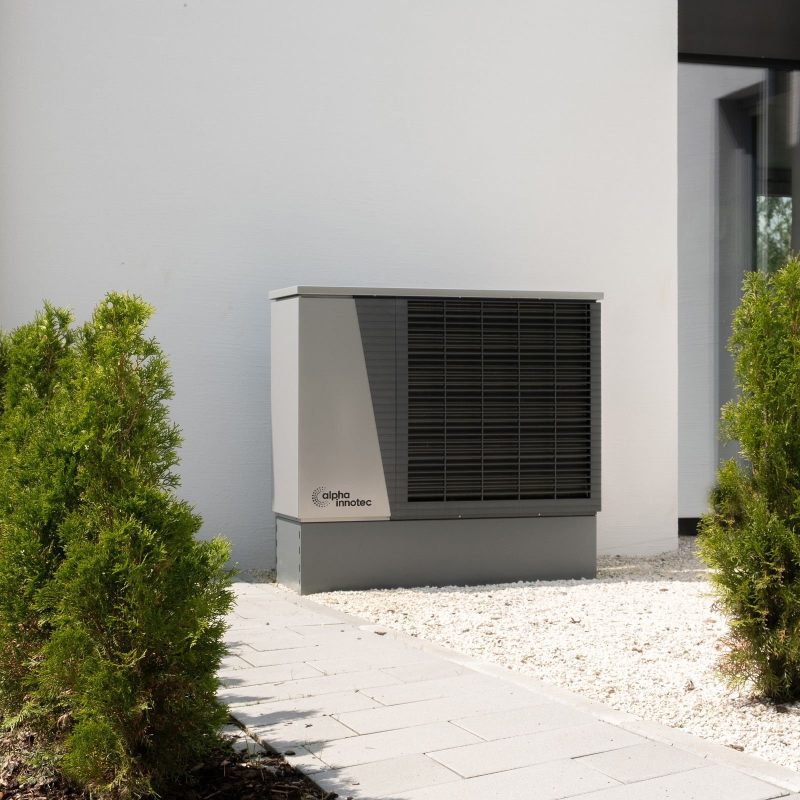 Wärmepumpe Luft-Wasser-Wärmepumpe vor einem Wohnhaus – erneuerbare Energiesysteme von SOS Gebäudetechnik