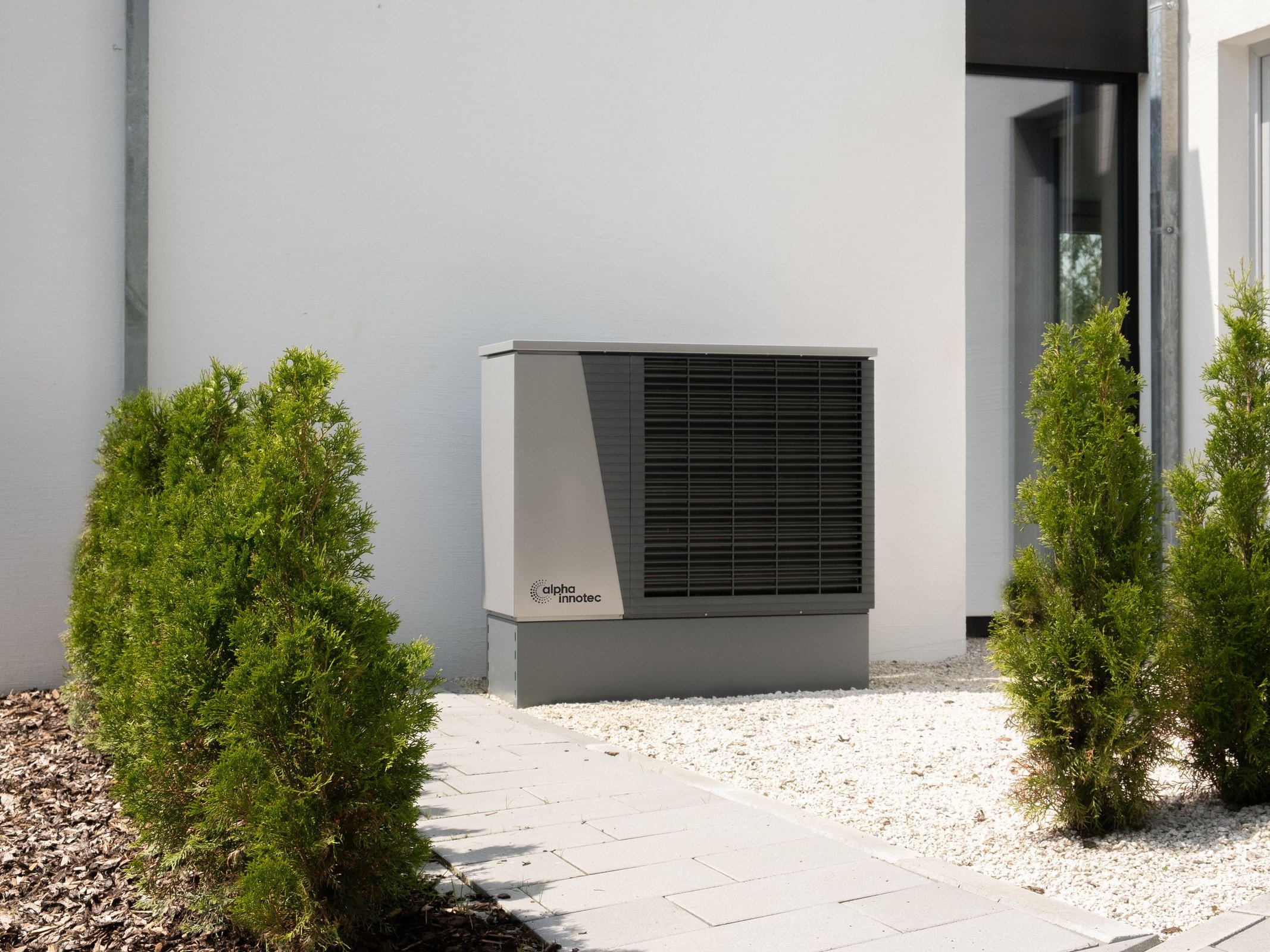 Wärmepumpe Luft-Wasser-Wärmepumpe vor einem Wohnhaus – erneuerbare Energiesysteme von SOS Gebäudetechnik
